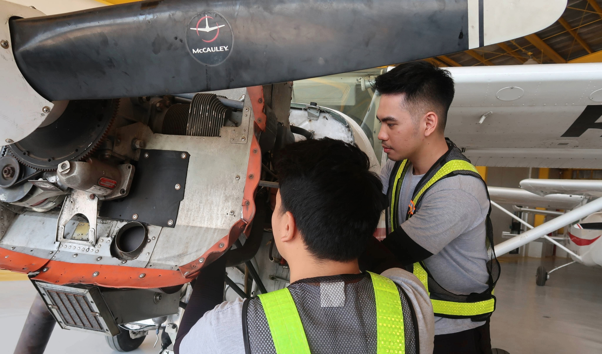 LEIAAI maintenance students working on an aircraft engine in the hangar
